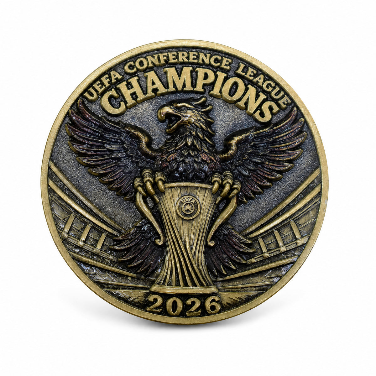 Moneda con águila, trofeo e inscripción UEFA Conference League Champions 2026.