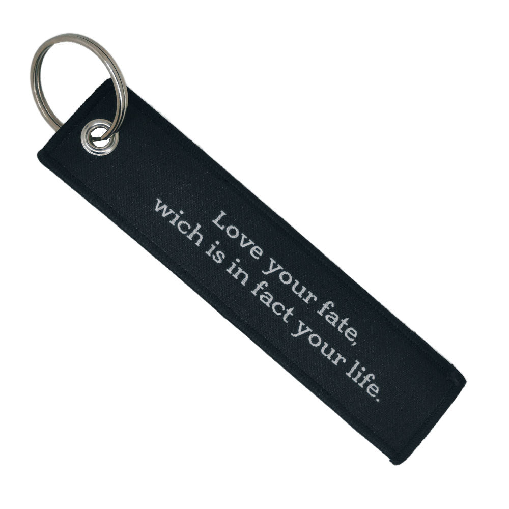 Double-sided embroidered Fabric Keychain with Amor Fati Phrase 13 x 3 cm