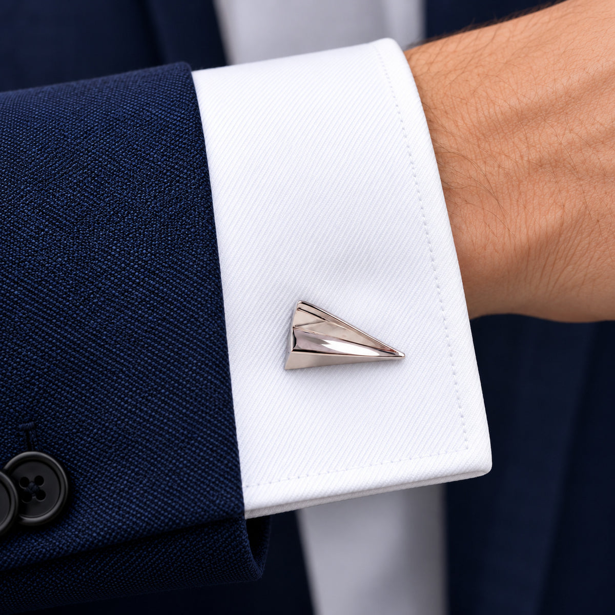 Gemelos Avión de Papel. Un gemelo en el puño blanco de una camisa.