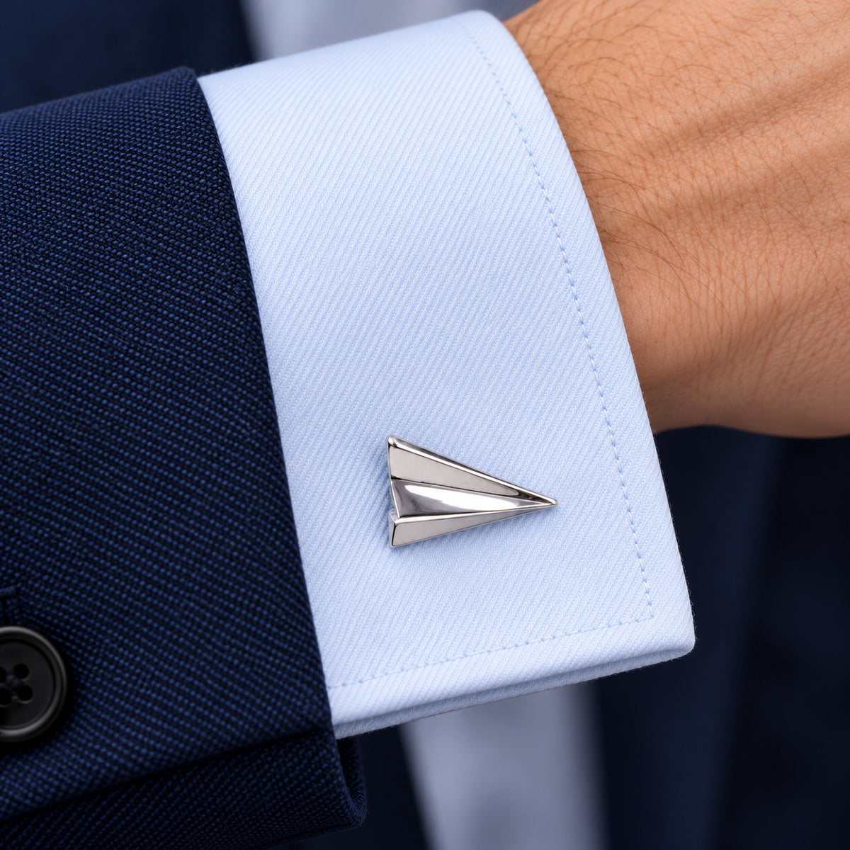 Gemelos Avión de Papel. Un gemelo en el puño azul de una camisa.