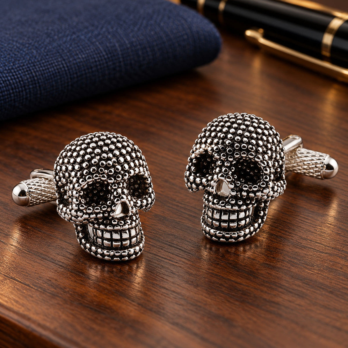 Gemelos para camisa Calavera Black and Steel Dotted. Par sobre una mesa de madera.