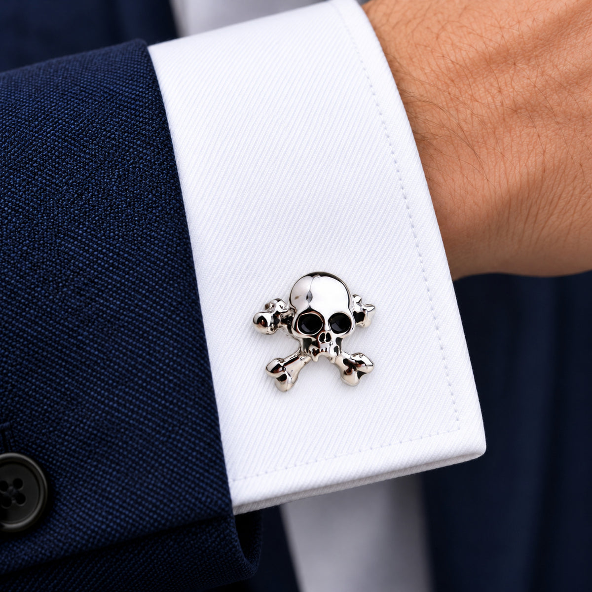 Gemelos Calaveras IV. Un gemelo en el puño blanco de una camisa.