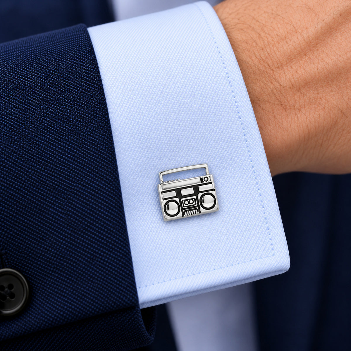 Gemelos Cinta y Radiocassette. Gemelo con forma de radiocassette en el puño azul claro de una camisa.
