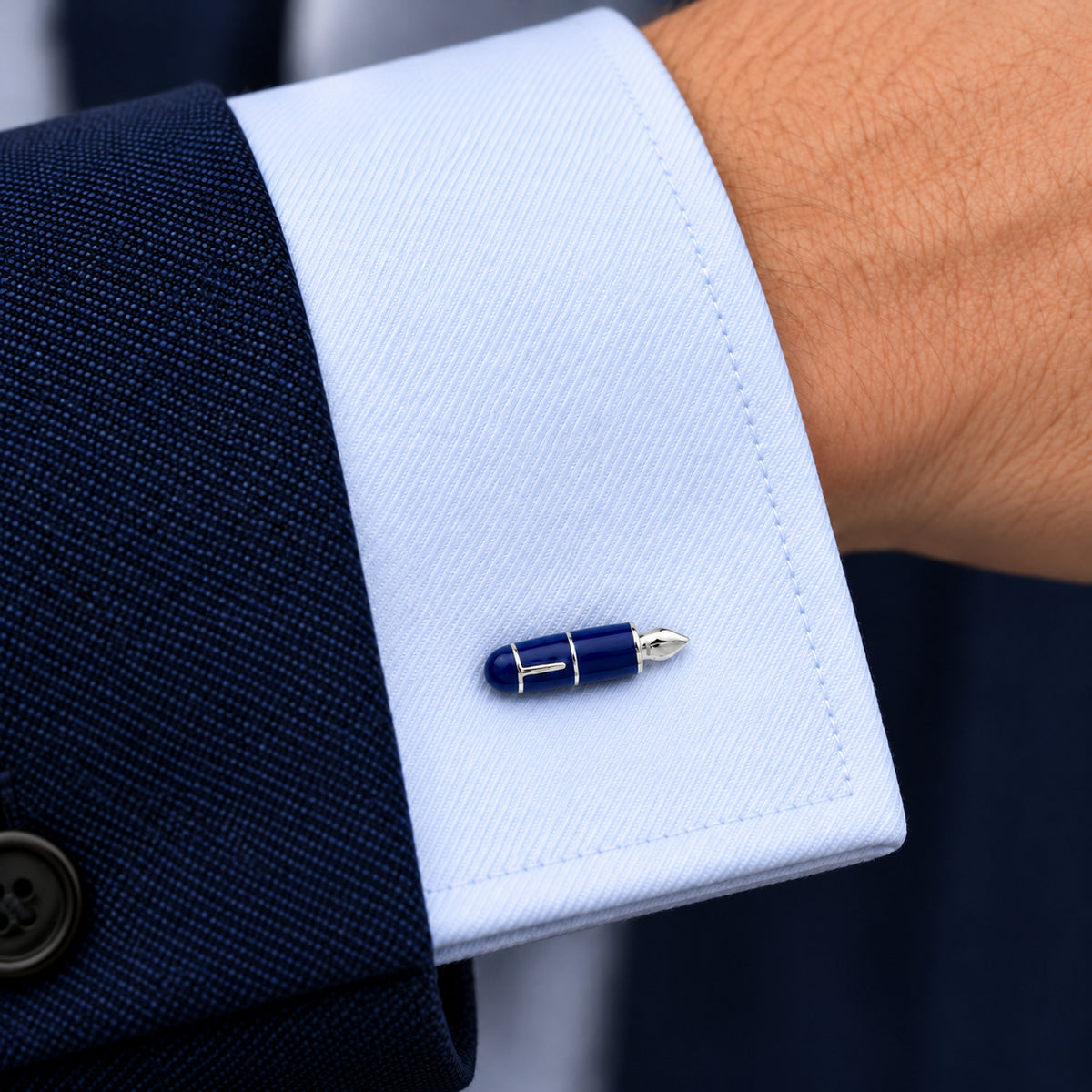 Gemelos Pluma Estilográfica Azul. Un gemelo en el puño azul claro de una camisa.